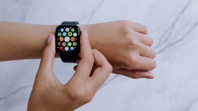 Close-up of hands interacting with a smartwatch on a marble surface, embodying modern digital connectivity., tags: und deutschland - pexel